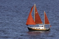 Sailing boat with red sails o...