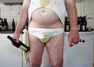 Scruffy man with empty beer b...