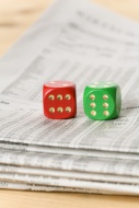 Red and green dice on a newsp...