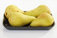 Four yellow pears on a plasti...