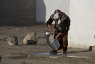 Kirghiz woman washing tin buc...