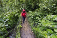 Hiker on a bridge in the clou...