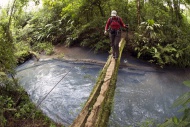 Hiker crossing the Rio Celest...