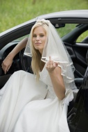 Bride sitting in a car, showi...