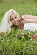 Bride lying on meadow, smilin...