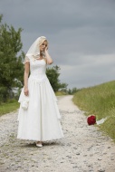 Bride standing on dirt track.