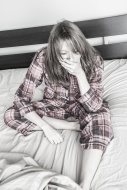 Young woman sitting on her bed.