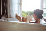 Woman relaxing in bathtub rea...