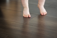 Feet of baby girl on dark floor