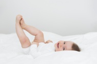 Smiling baby girl lying on bed