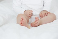 Baby girl sitting on bed