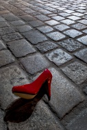 Red high heel lying on cobble...