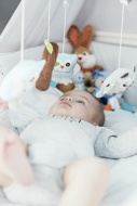 Baby lying in crib looking at...