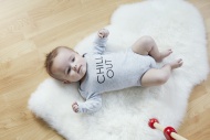 Baby lying on fur on floor