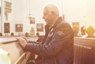 Senior man praying in a church
