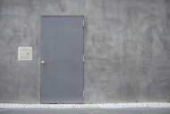 Grey steel door at concrete wall
