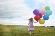 Little girl with balloons run...