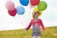Little girl with balloons on ...