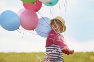 Little girl with balloons on ...