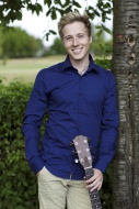 Smiling young man with guitar...