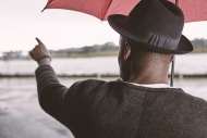 Young man with umbrella point...