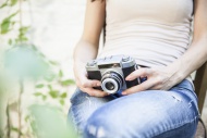 Sitting woman holding camera