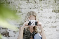 Blond woman taking a photo wi...