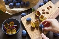 Plums on chopping board, pitting