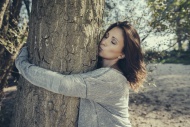Woman hugging and kissing a tree