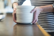 Hands holding stack of plates...