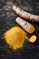Fresh Curcuma and powder on wood