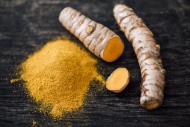 Fresh Curcuma and powder on wood