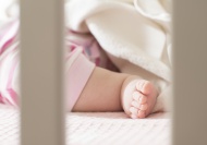 Foot of baby girl in a cot
