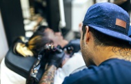 Woman receiving tattoo in tat...