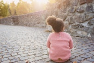 Little girl sitting on walkway