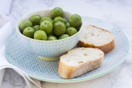 Bowl of green olives and slic...