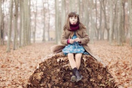 Young girl sitting on autum l...