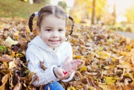 Happy girl in autumn leaves