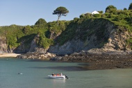 UK, Wales, Boat at cliffs of ...