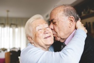 Senior couple hugging and kis...