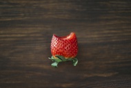 Bitten strawberry on dark wood