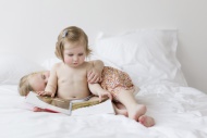 Toddler girl sitting on a whi...