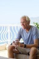 Smiling senior man on balcony...