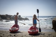 Senior couple pushing canoes ...