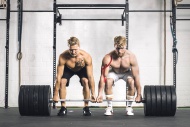 Two young men in gym lifting ...