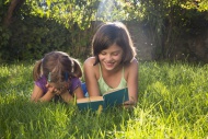 Girl on a meadow reading out ...