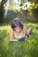 Girl reading book on a meadow