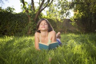 Happy girl lying on meadow wi...