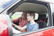 Father teaching son driving a...