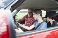 Father teaching son driving a...